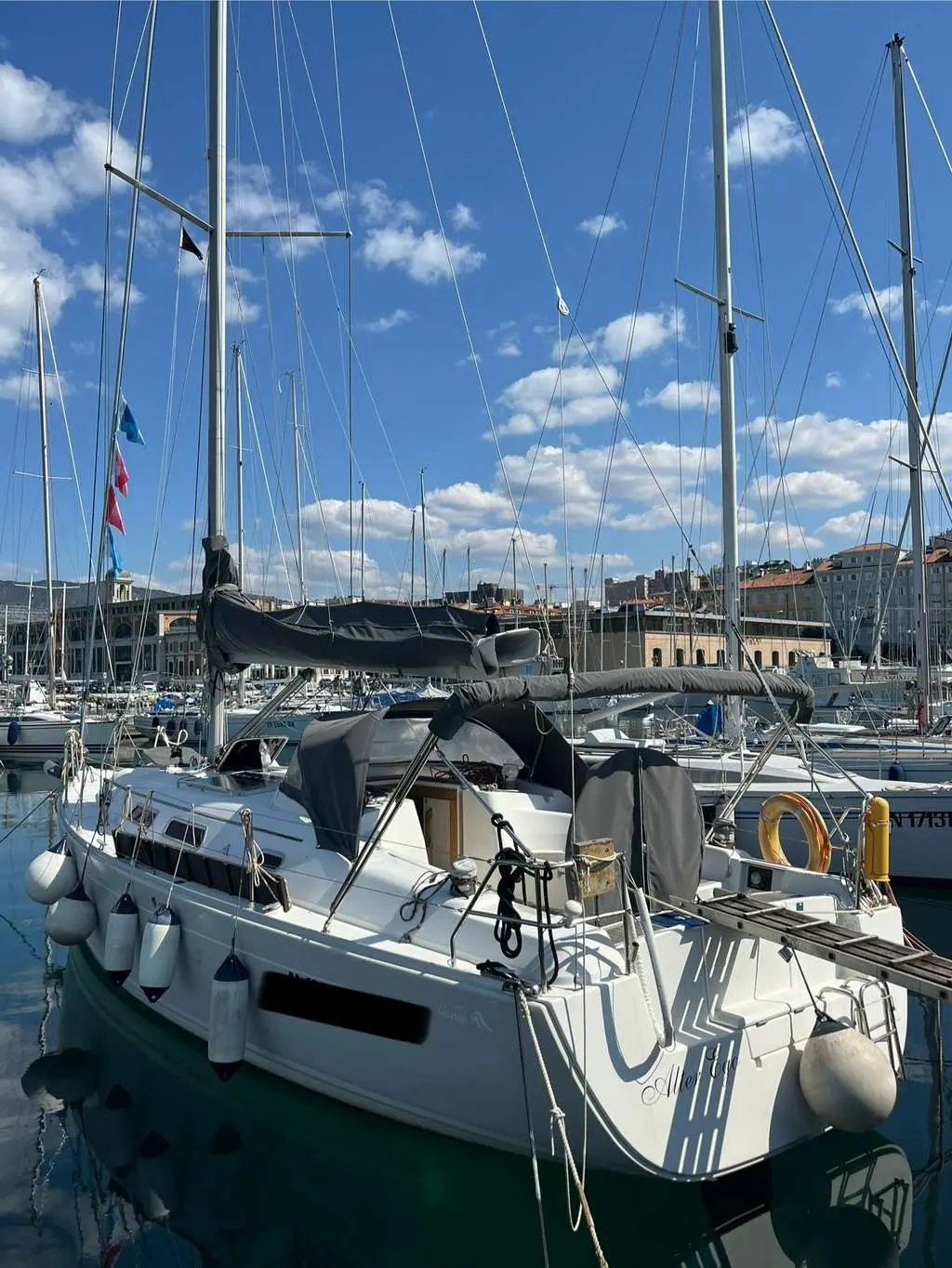 Hanse 370 — Voilier blanc amarré dans un port, vu de trois quarts arrière.