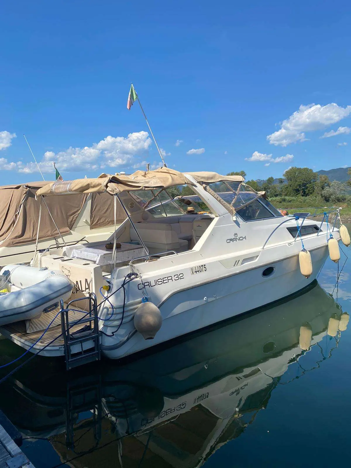 Cranchi 32 Cruiser — Bateau à moteur amarré, vu de trois quarts, sous un ciel dégagé.