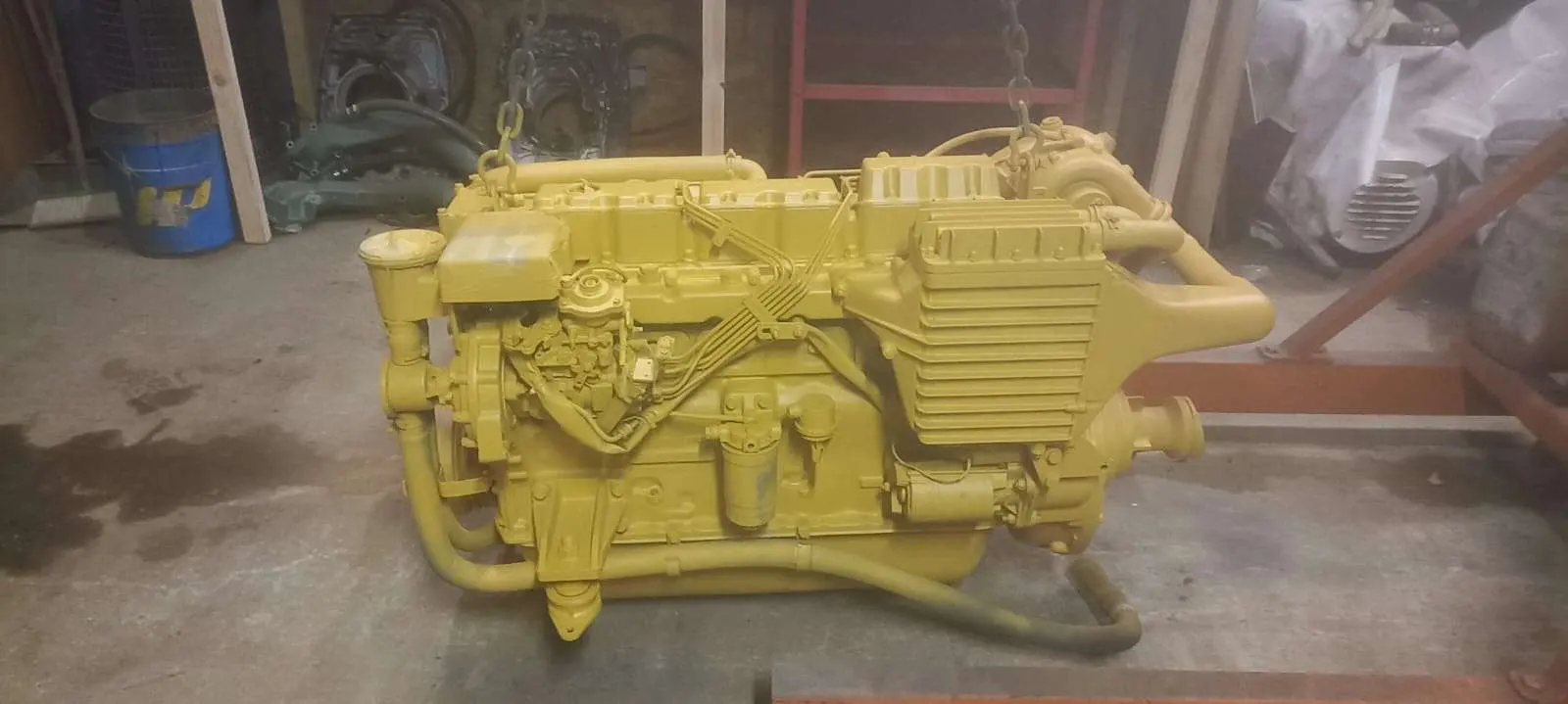 Cranchi 32 Cruiser — Moteur marin jaune photographié au sol dans un atelier.