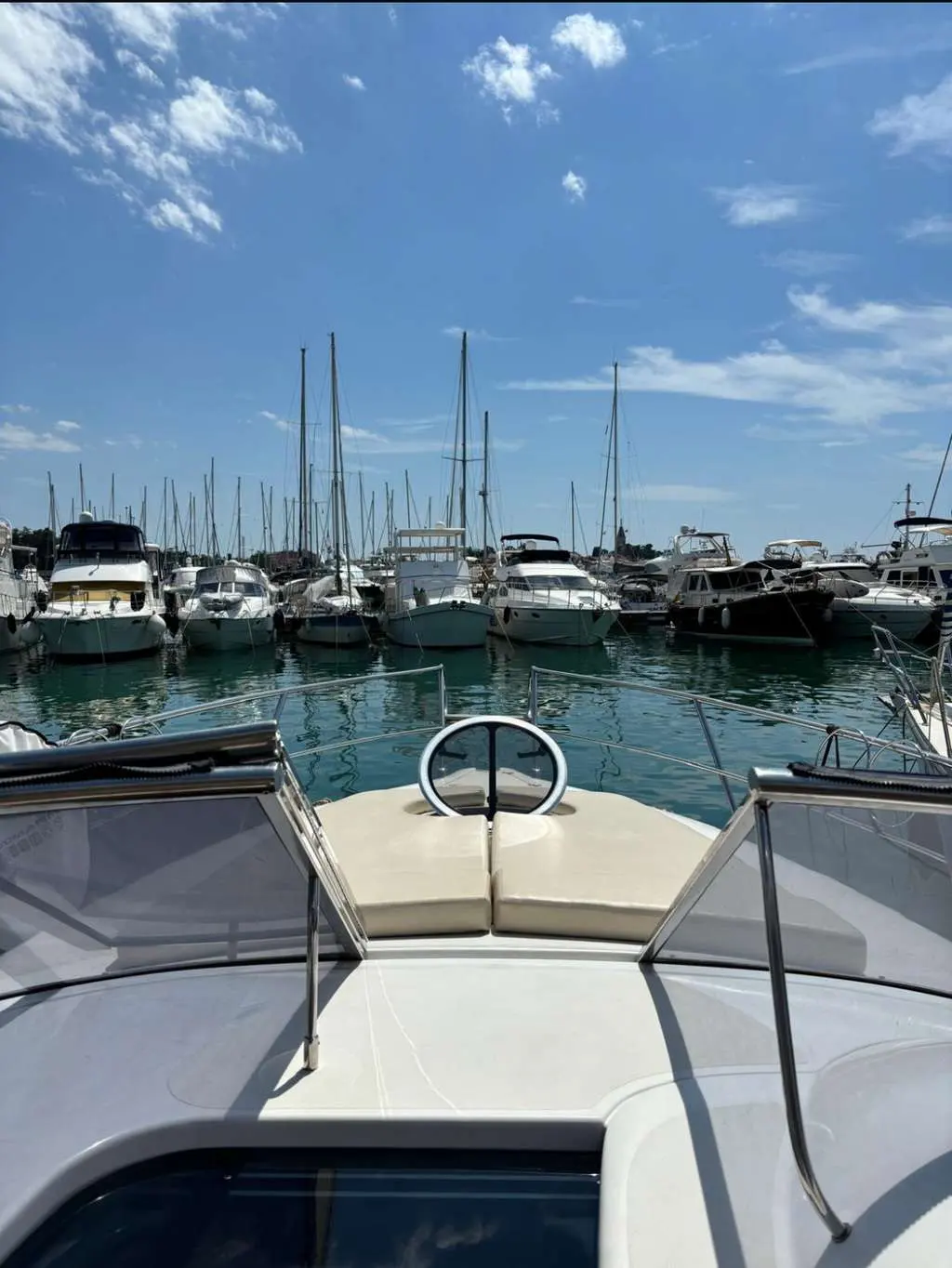 Sessa Marine C30 Hard-Top — Vue de l’avant d’un bateau amarré dans une marina, avec d’autres bateaux en arrière-plan.