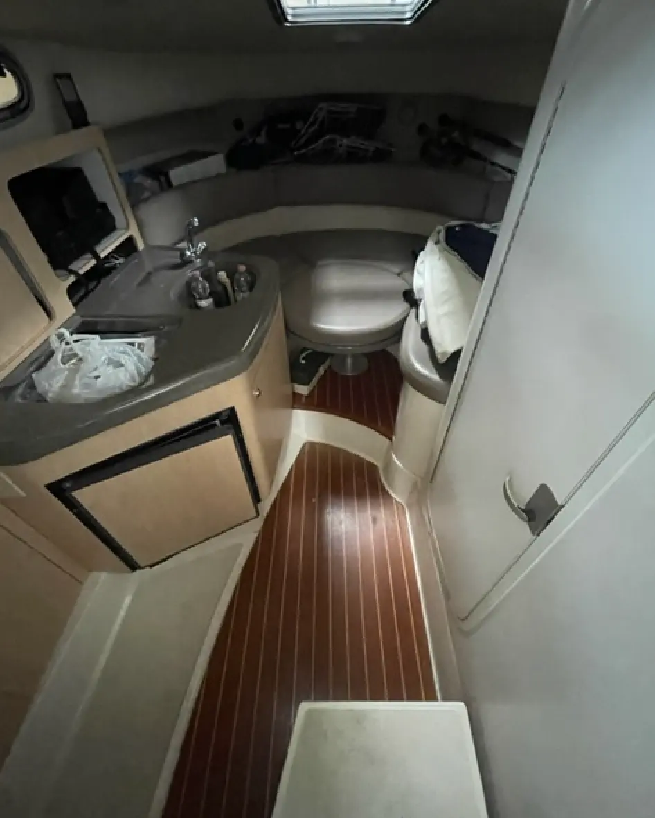 Boston Whaler 28 Conquest — Vue intérieure d'une cabine avec évier, rangements et banquette.