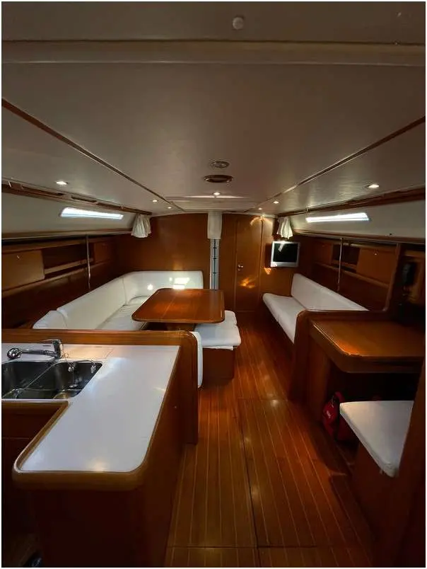 Grand Soleil 50 — Vue intérieure du carré et de la cuisine aménagés en bois.