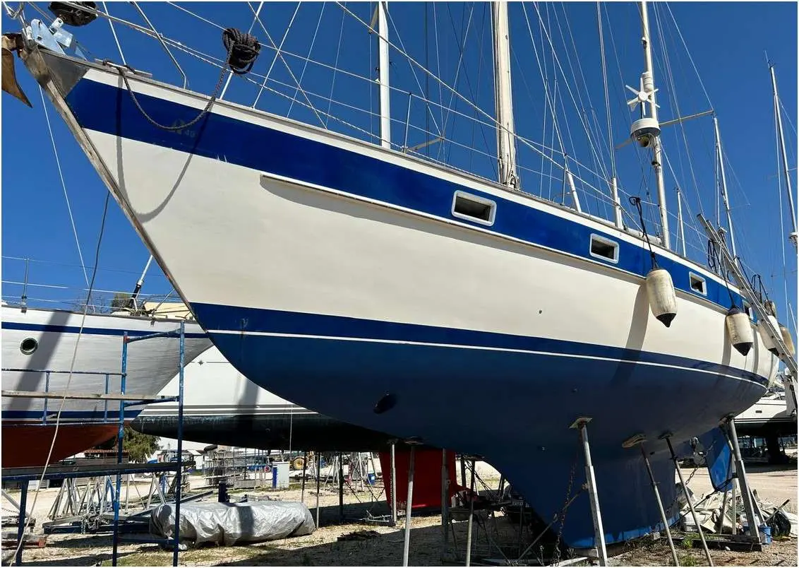 Hallberg Rassy 49 — Voilier blanc et bleu photographié à terre, vu de l’avant tribord.