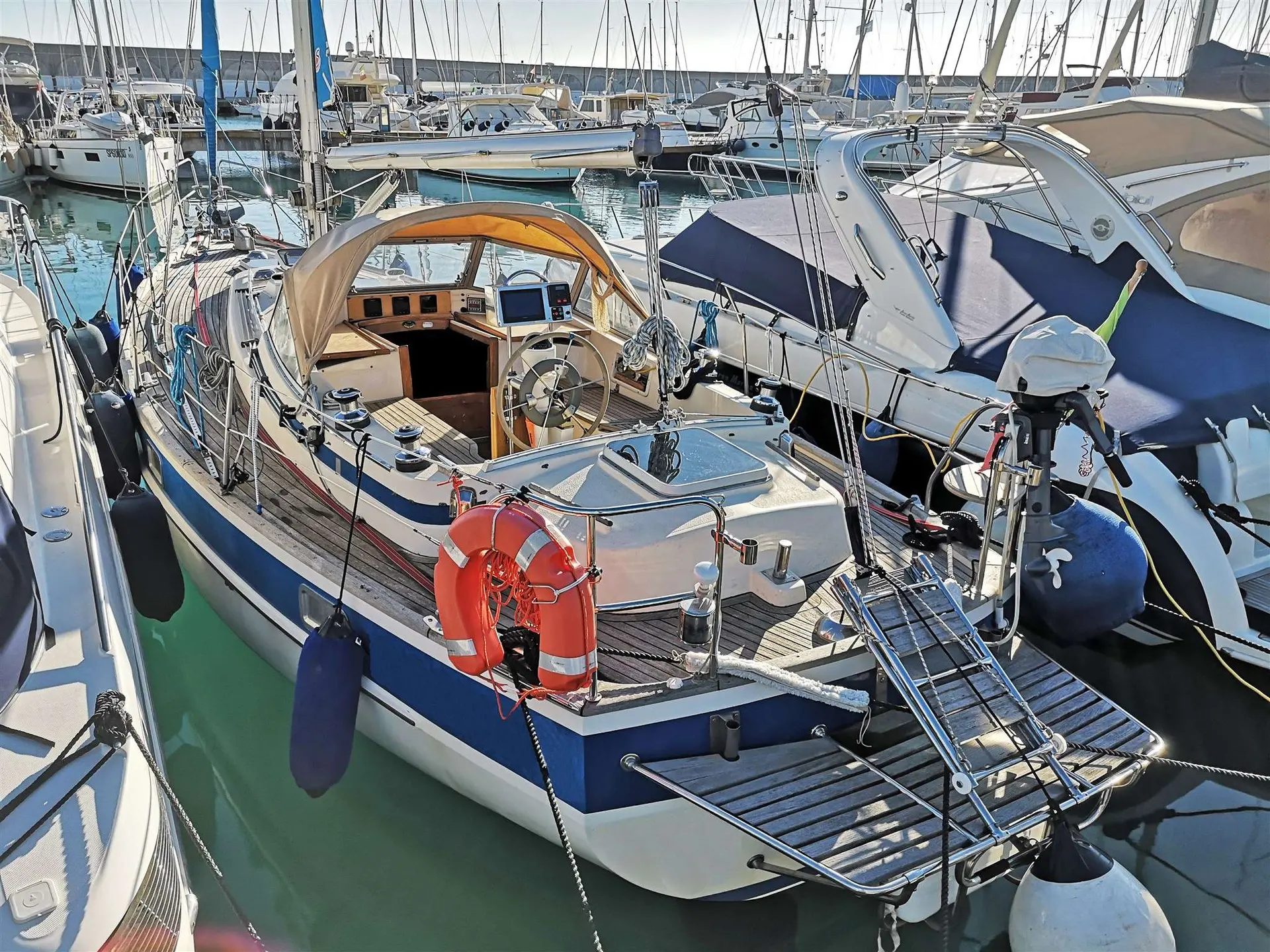 Hallberg Rassy 352 — Voilier amarré dans une marina, vu de l'arrière avec son cockpit et son gréement.