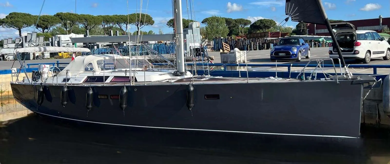 Hanse 540 — Voilier vu de profil, amarré le long d’un quai dans un chantier nautique.