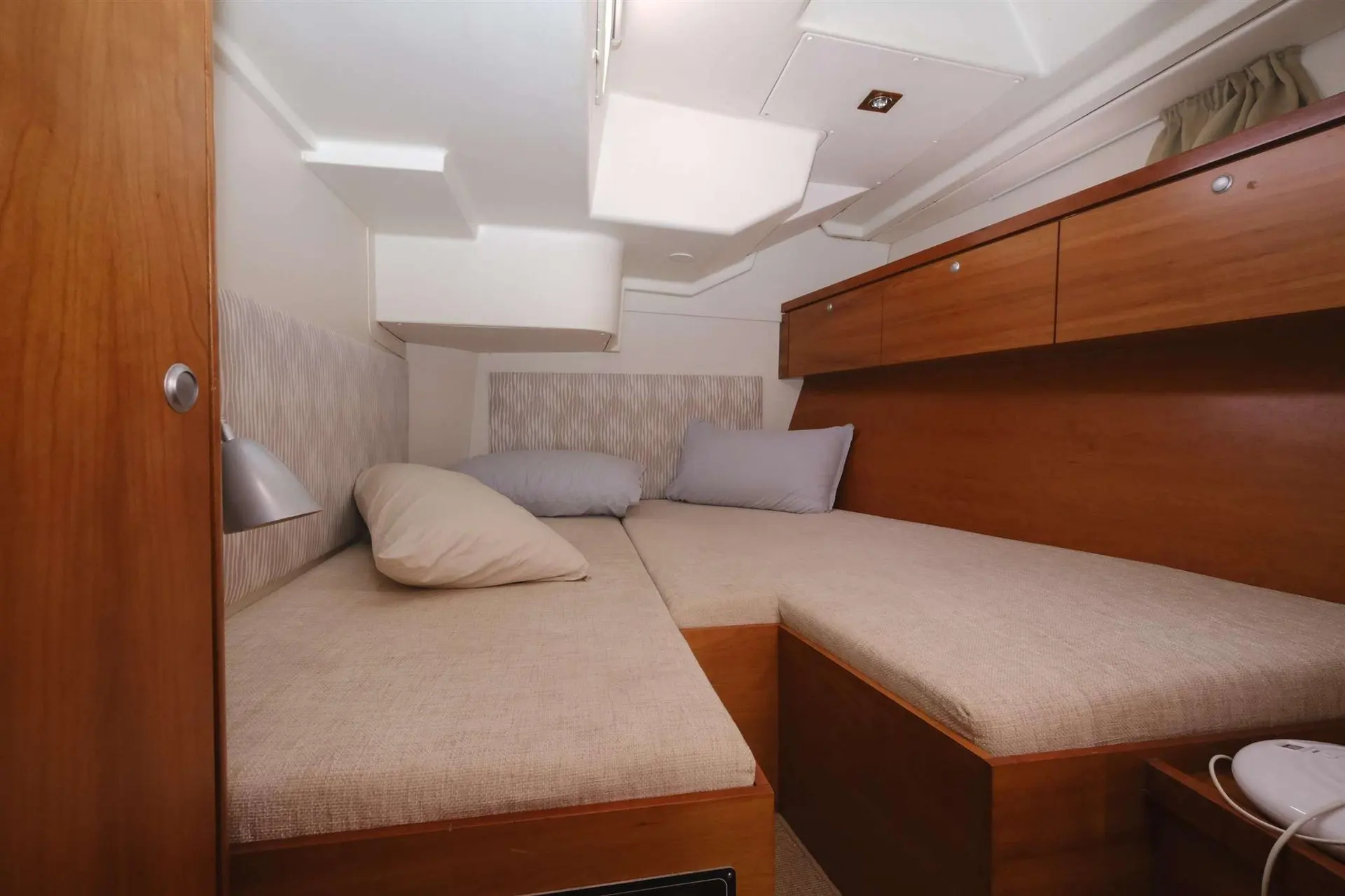 Hanse 540 — Cabine double intérieure avec couchettes, rangements en bois et coussins.