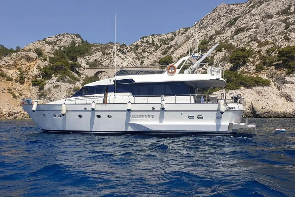 San Lorenzo 70 — Bateau à moteur blanc vu de profil dans une crique rocheuse.