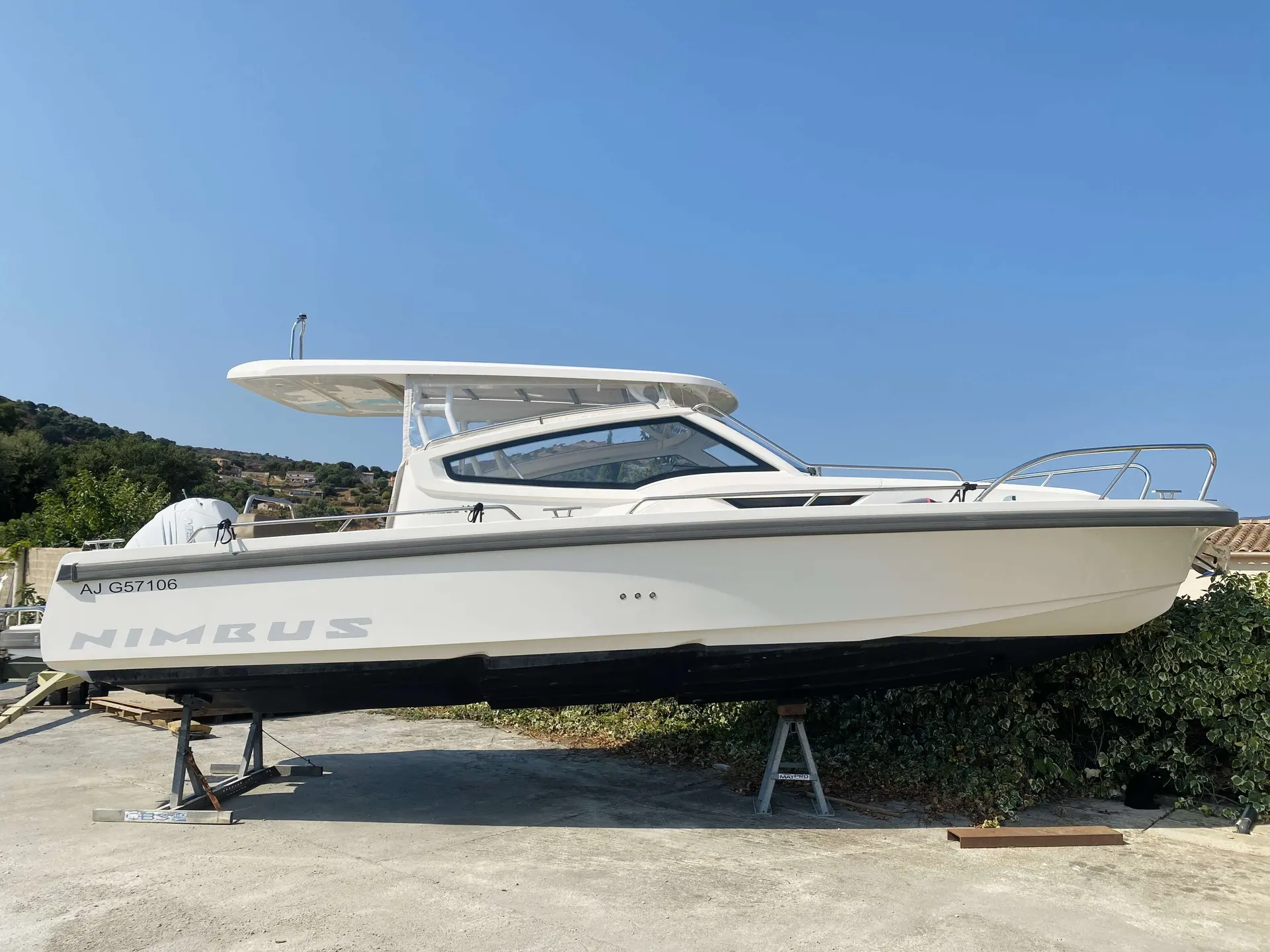 Nimbus W9 — Vue latérale d’un bateau blanc à cabine, posé sur des bers à terre.