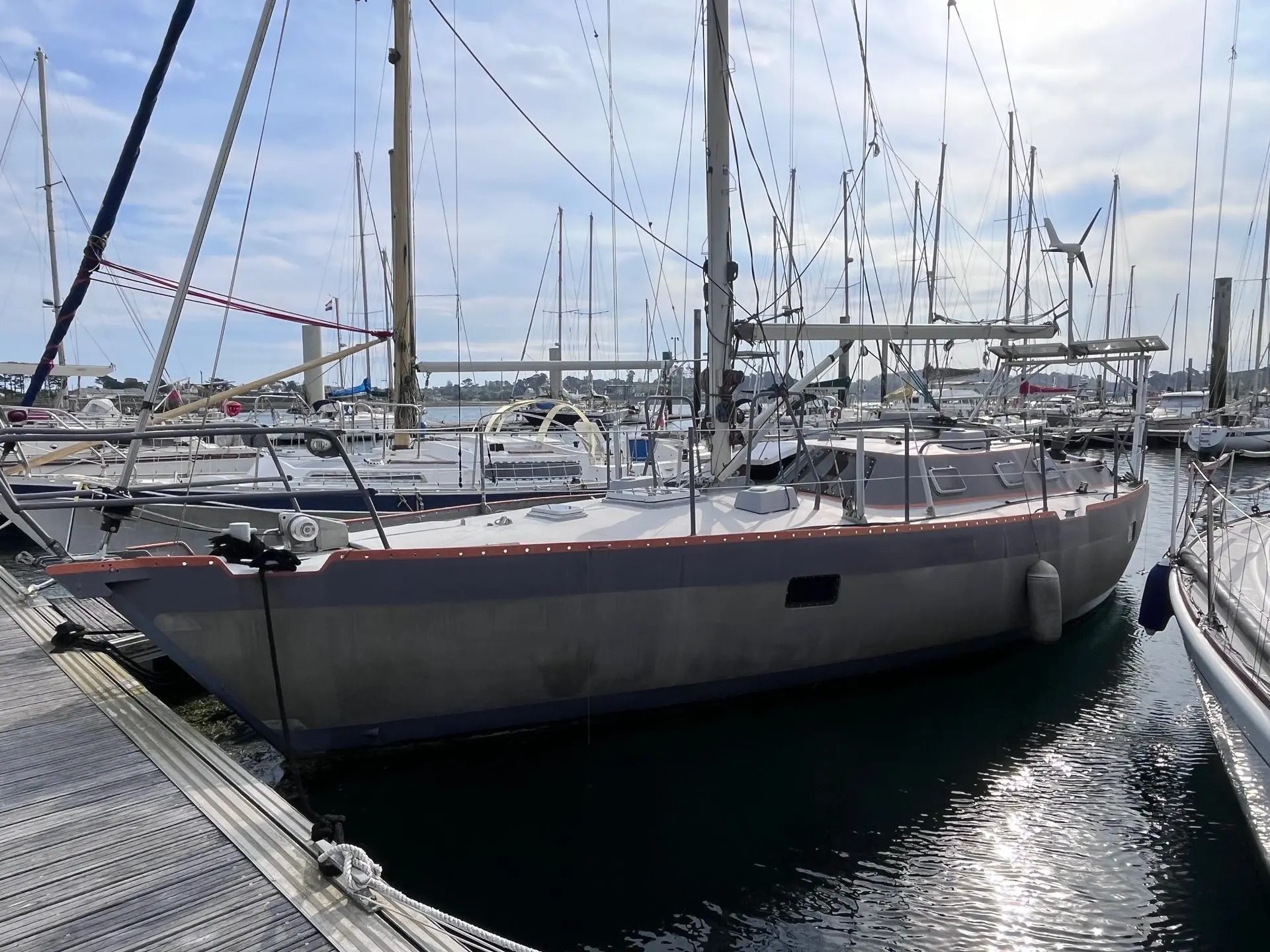 Garcia CARAMBOLA — Voilier gris amarré dans une marina, vu de trois quarts.