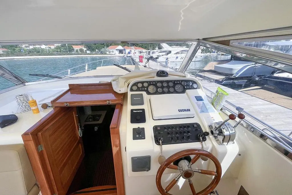 Apreamare 38 Open — Poste de pilotage intérieur avec instruments, commandes et vue sur le port.