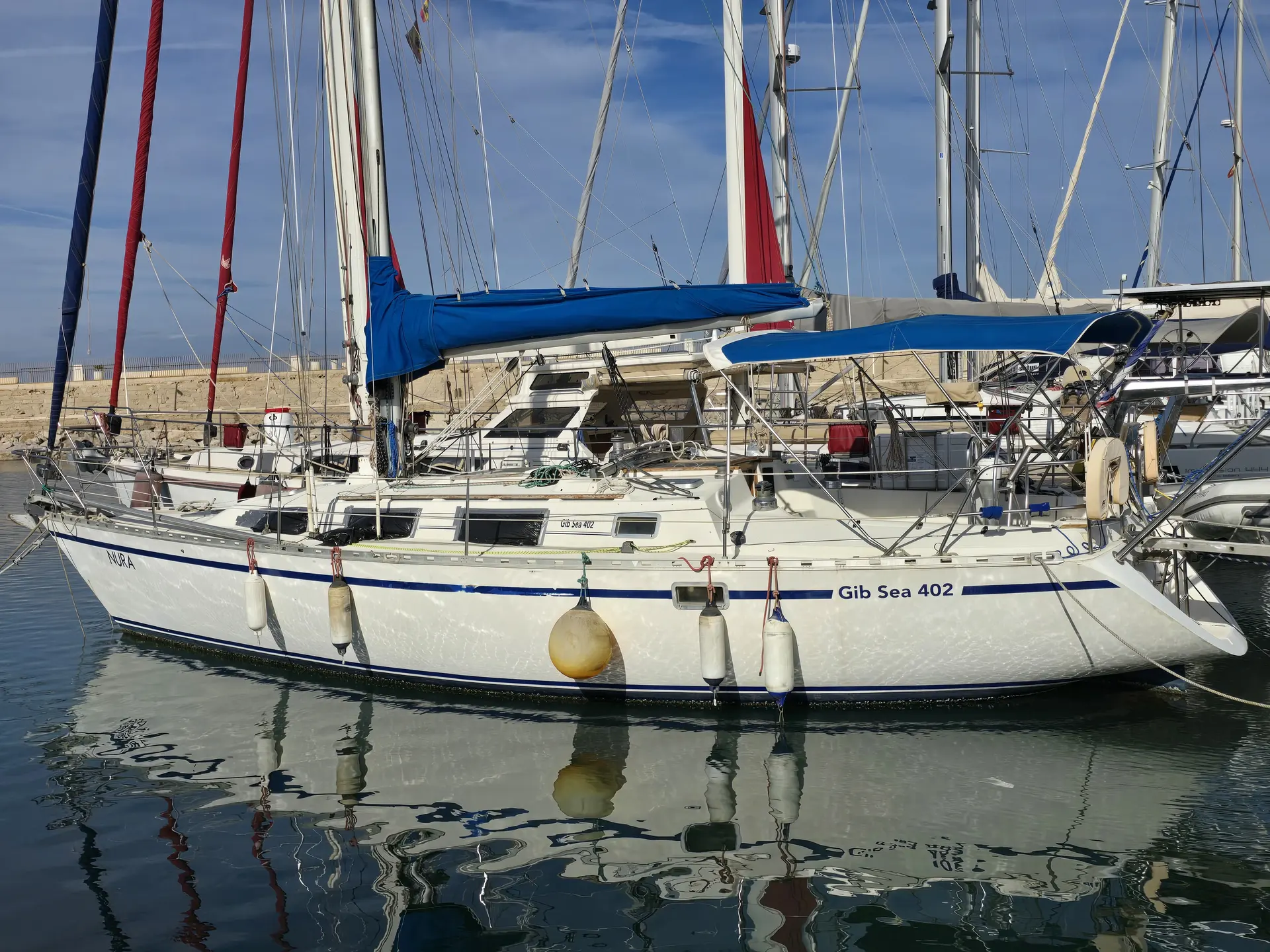 Gibert Marine Gib Sea 402 — Voilier blanc amarré dans un port, vu largement de profil.