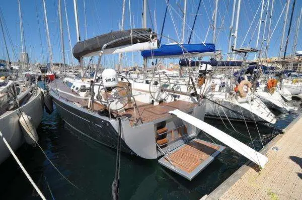 Solaris 44 — Voilier vu de trois quarts arrière, amarré dans un port parmi d’autres bateaux.