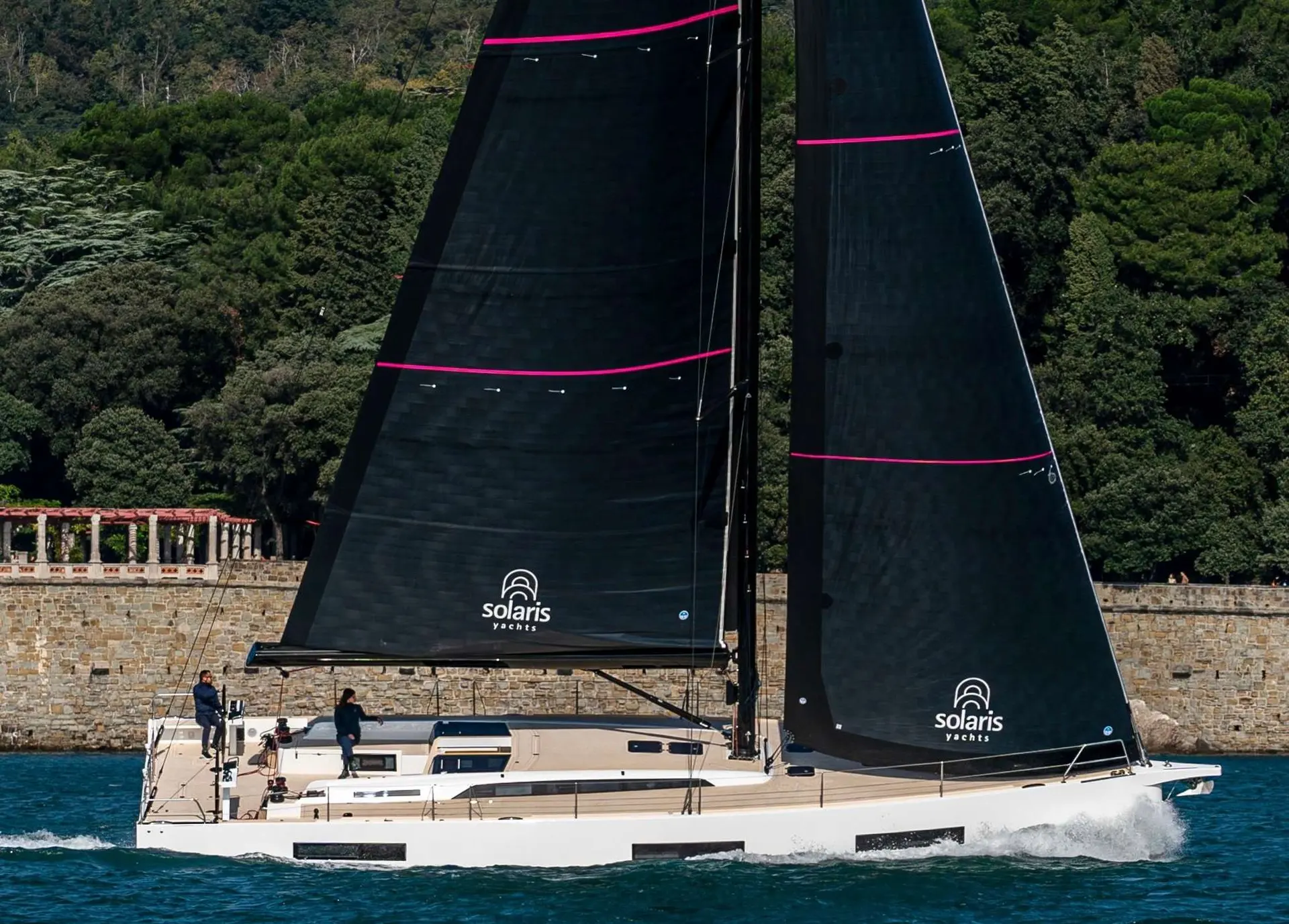 Solaris 55 — Voilier blanc naviguant au large, toutes voiles noires hissées.