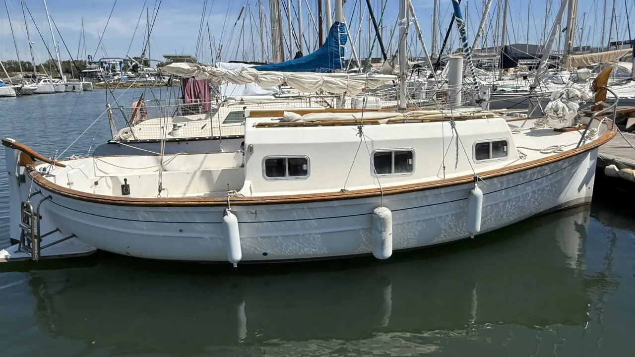 Mallorca Myabca — Voilier blanc à cabine amarré dans une marina, vu de profil.