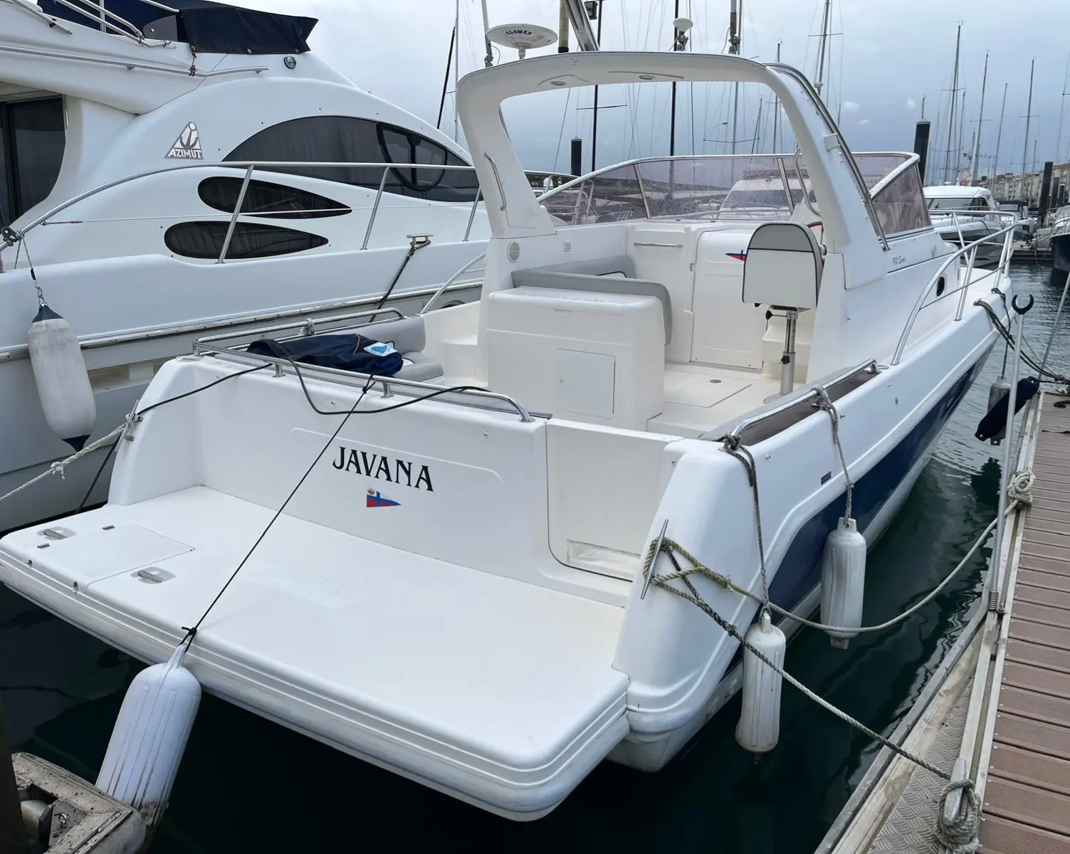 Faeton 980 Open — Vue arrière trois-quarts d’un bateau blanc amarré dans un port.