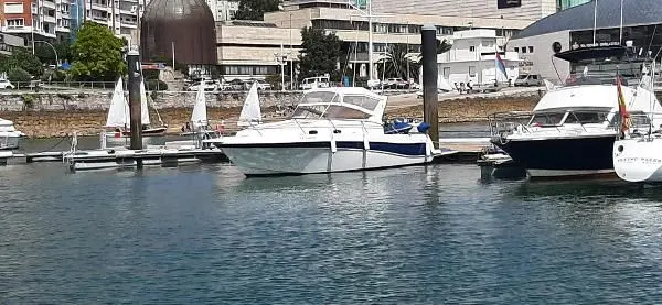 Faeton 980 Open — Bateau à moteur blanc amarré dans un port, parmi d’autres embarcations.