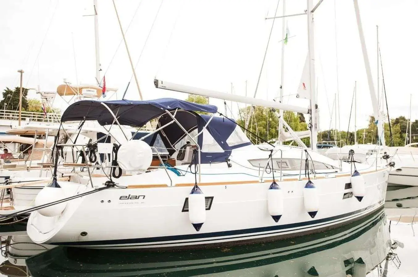 Elan Impression 40 — Voilier blanc amarré dans une marina, vu de trois quarts bâbord.