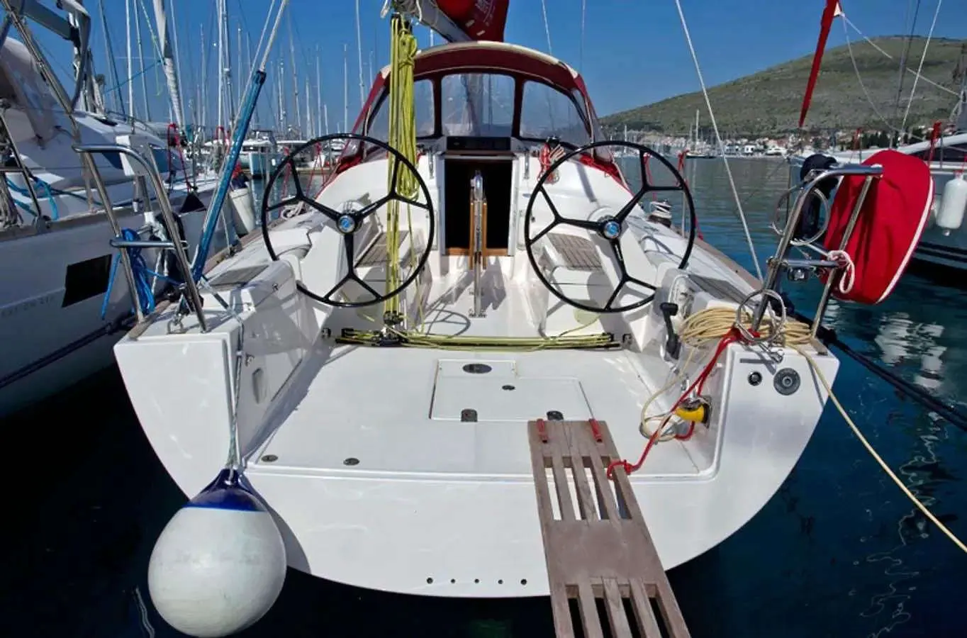 Salona 35 — Vue arrière du cockpit d’un voilier amarré, avec deux barres à roue et gréement visible.