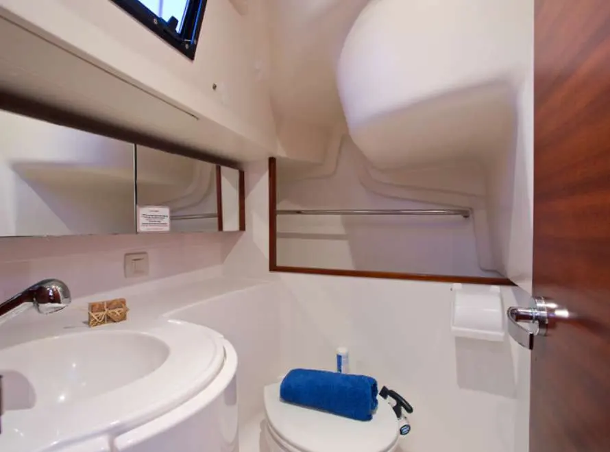 Salona 35 — Salle d’eau à bord avec lavabo, miroir et toilettes.