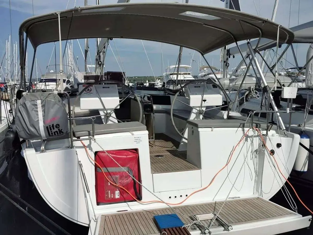 Hanse 455 — Vue arrière du cockpit d’un voilier amarré, sous une capote, dans une marina.