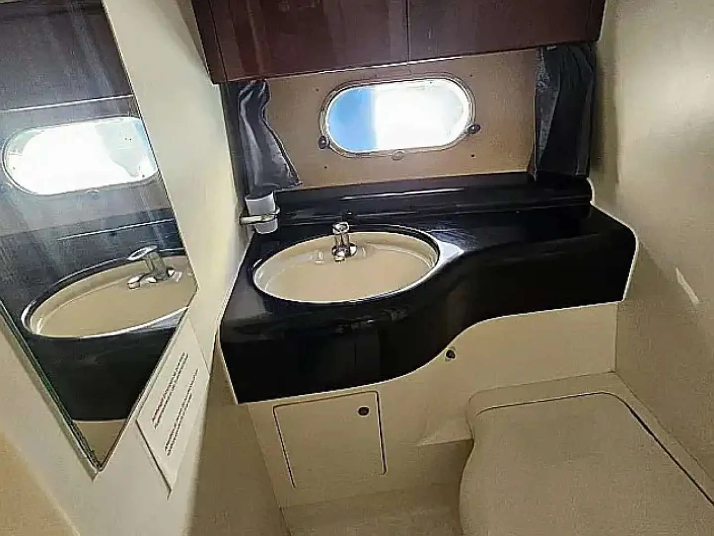 Princess 480 — Salle d’eau avec lavabo, miroir et hublot à bord du bateau.