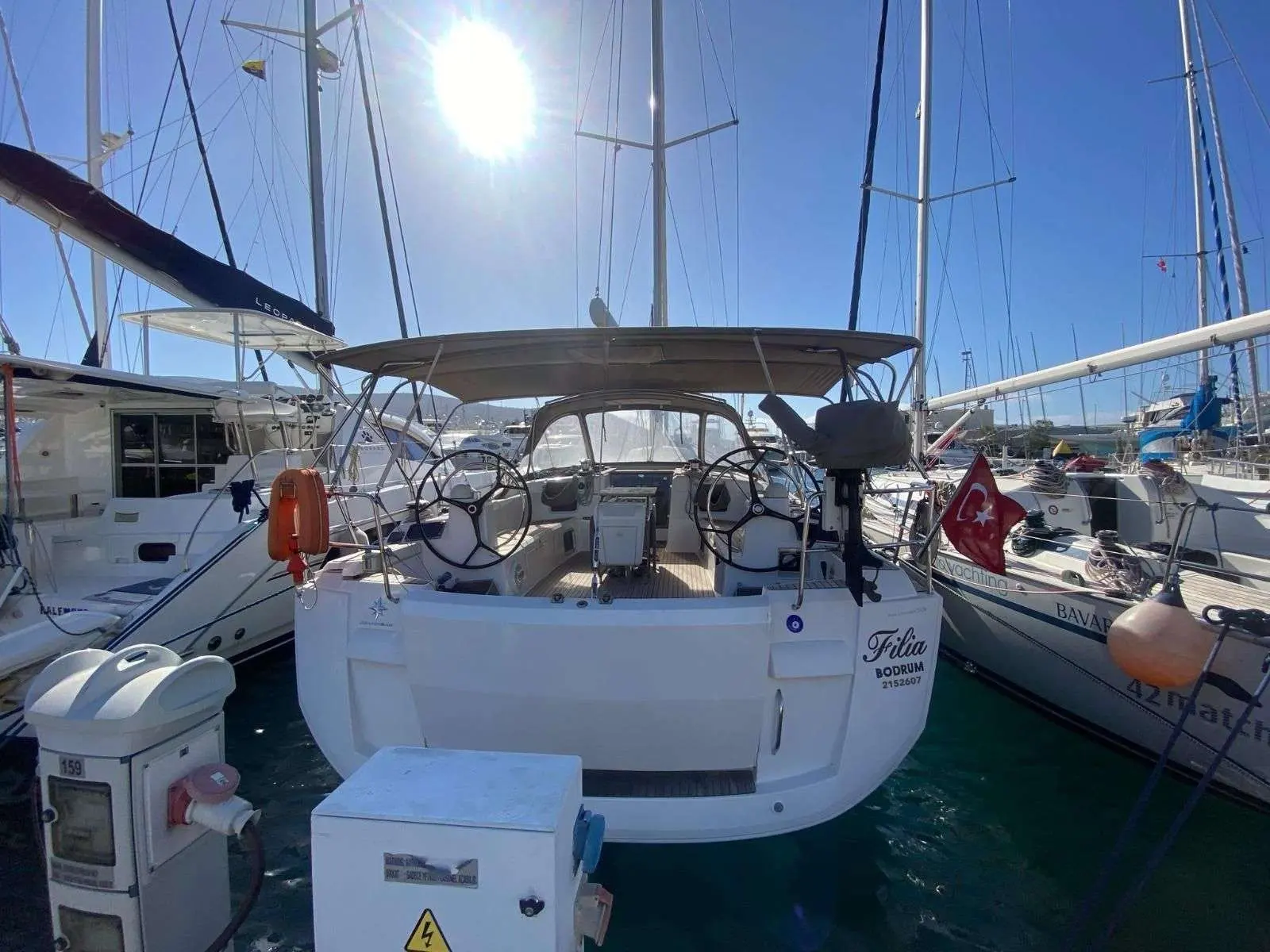 Jeanneau Sun Odyssey 509 — Vue arrière du cockpit d’un voilier amarré, entre plusieurs bateaux.