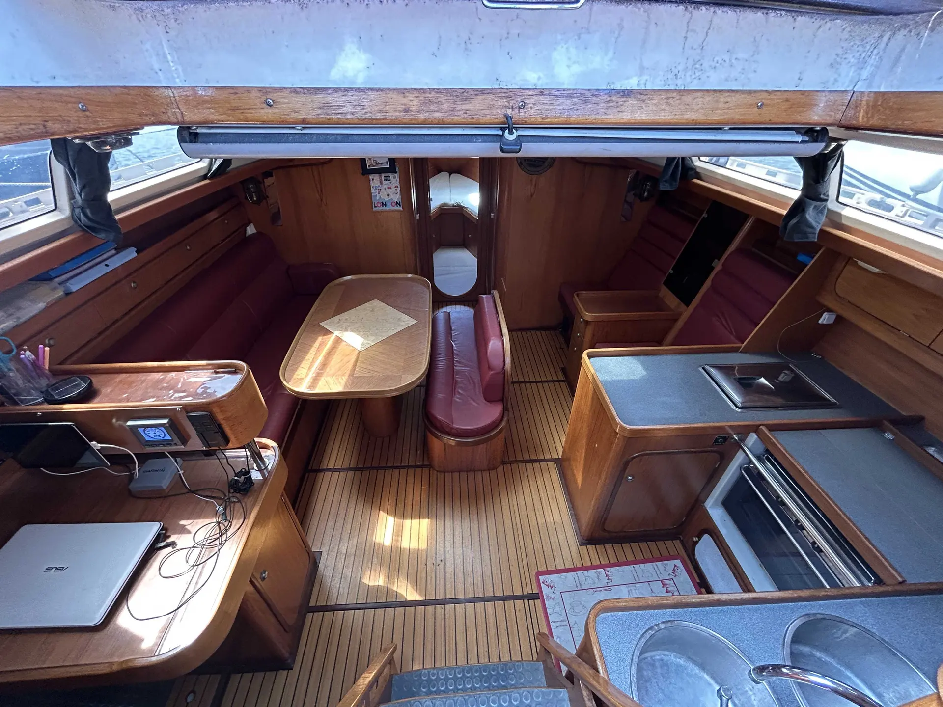 Gib Sea 42 — Vue intérieure du carré et de la cuisine, avec table, banquettes et descente.
