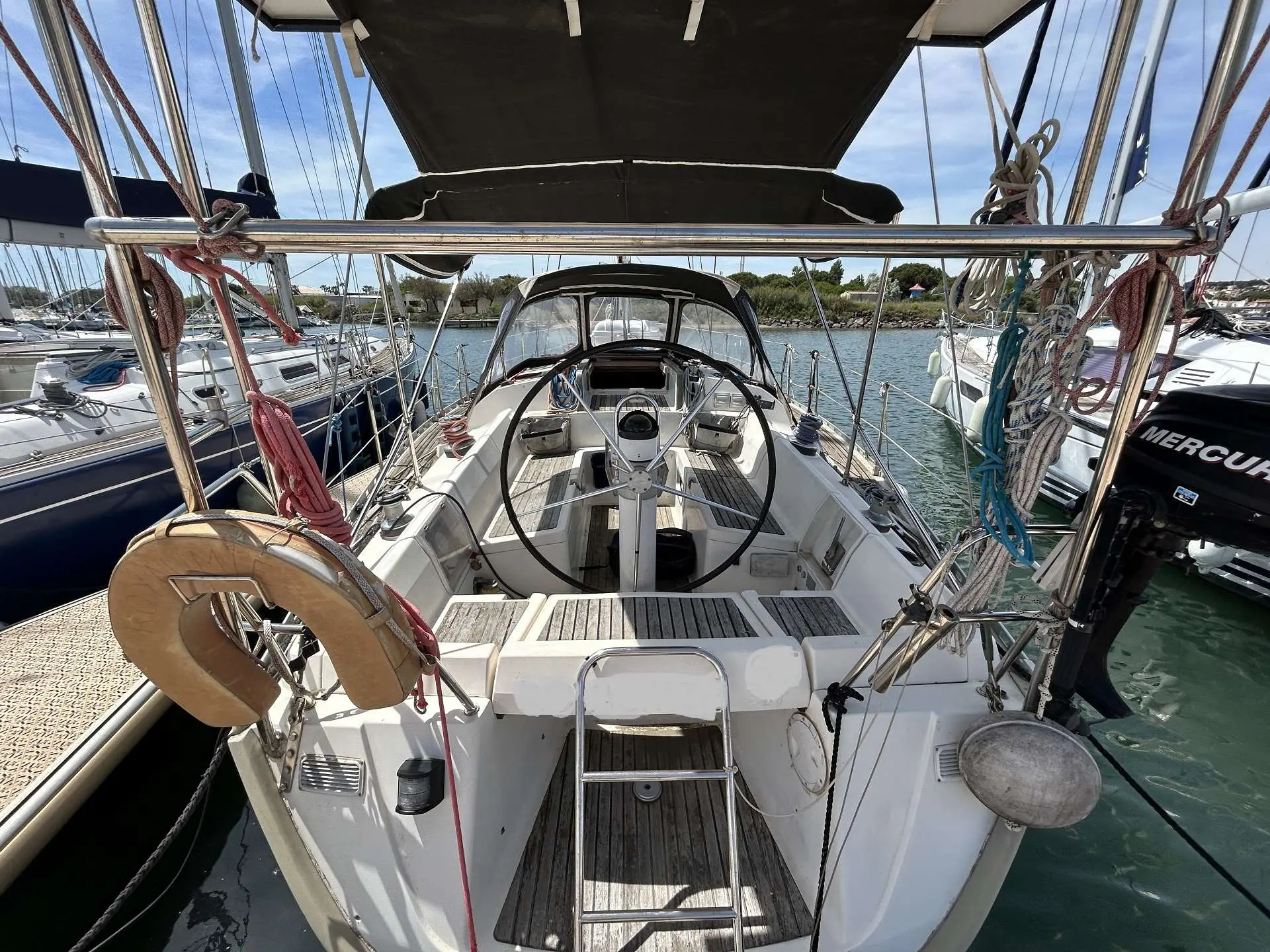 Gib Sea 42 — Vue arrière du cockpit d'un voilier amarré, avec barre à roue et gréement visible.
