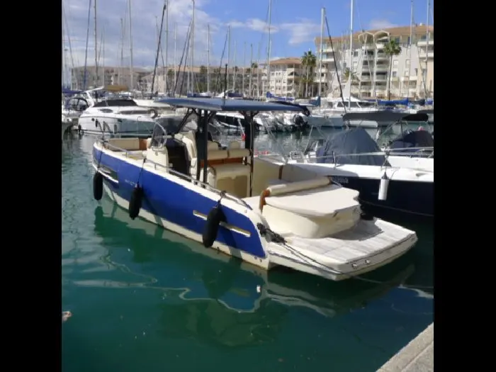 Invictus 280 TT — Bateau à moteur bleu et blanc amarré dans un port de plaisance.