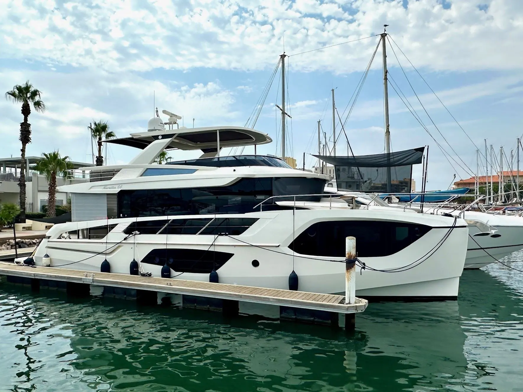 Absolute Navetta 64 — Bateau à moteur blanc amarré dans une marina, vu de trois quarts bâbord.