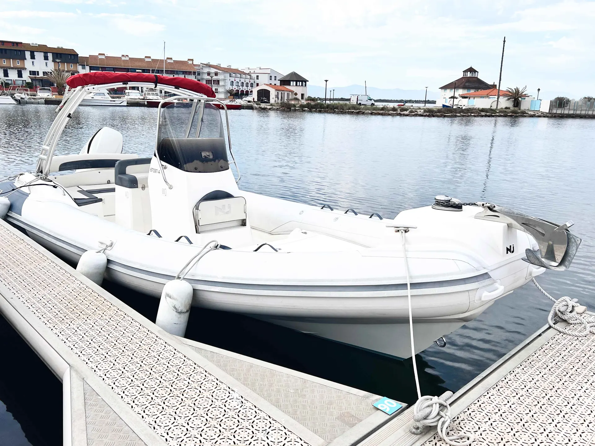 Nuova Jolly Prince 23 — Bateau pneumatique blanc amarré à un ponton, vu de trois quarts.