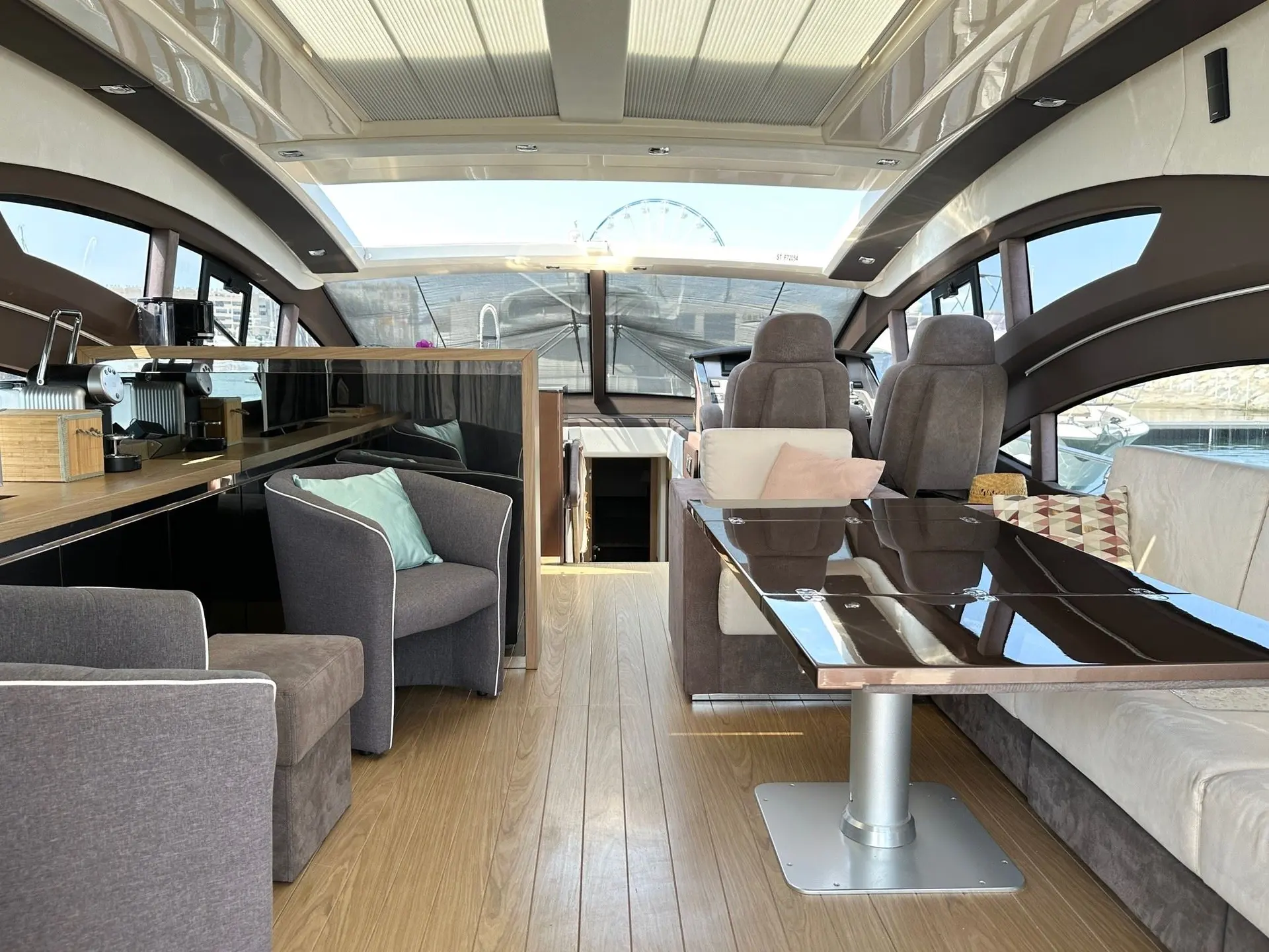 Sessa Marine C68 — Vue intérieure du salon avec table, sièges, cuisine et poste de pilotage.