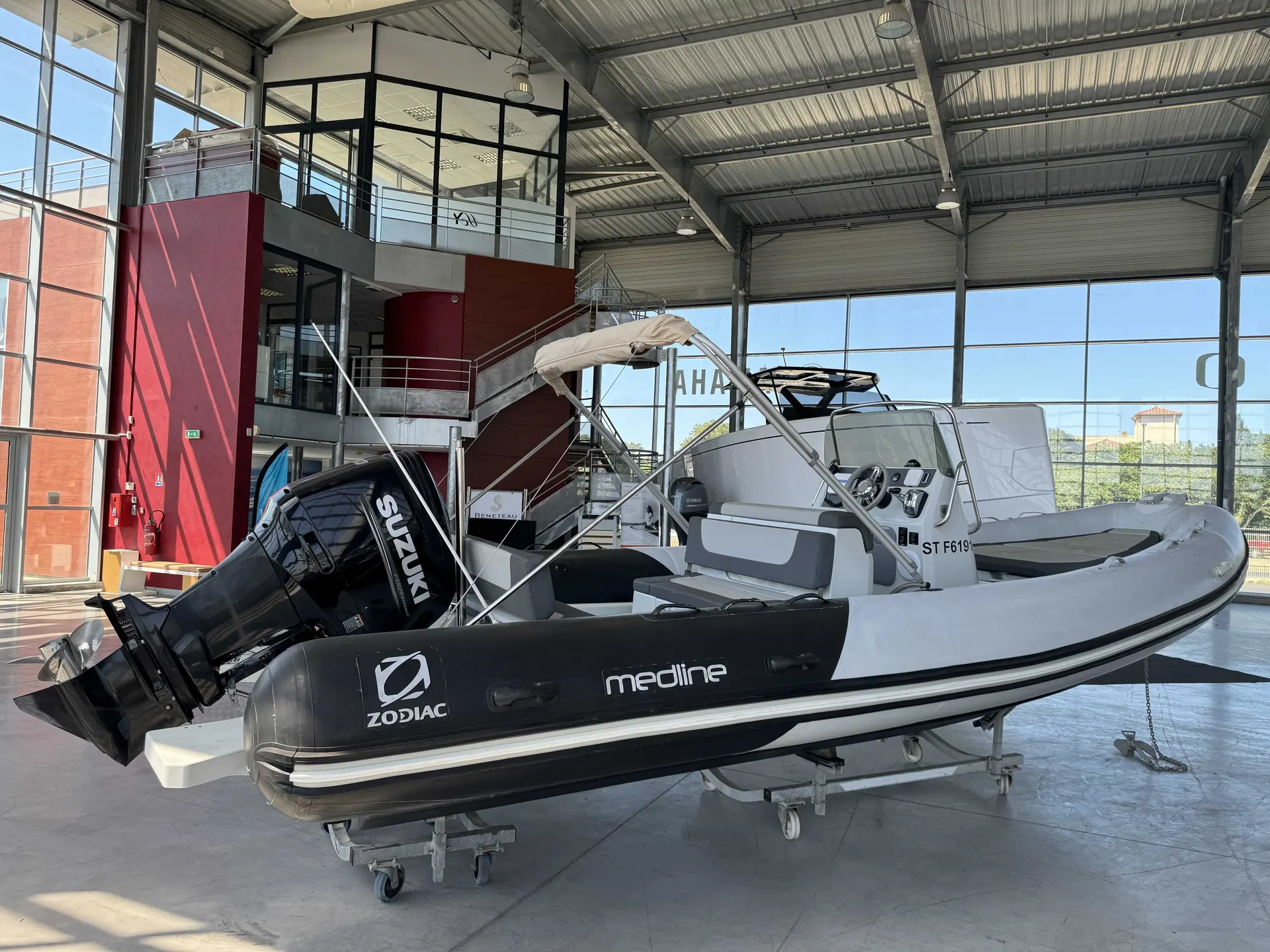 Zodiac Medline 740 — Bateau semi-rigide blanc et noir présenté à l’intérieur d’un showroom.