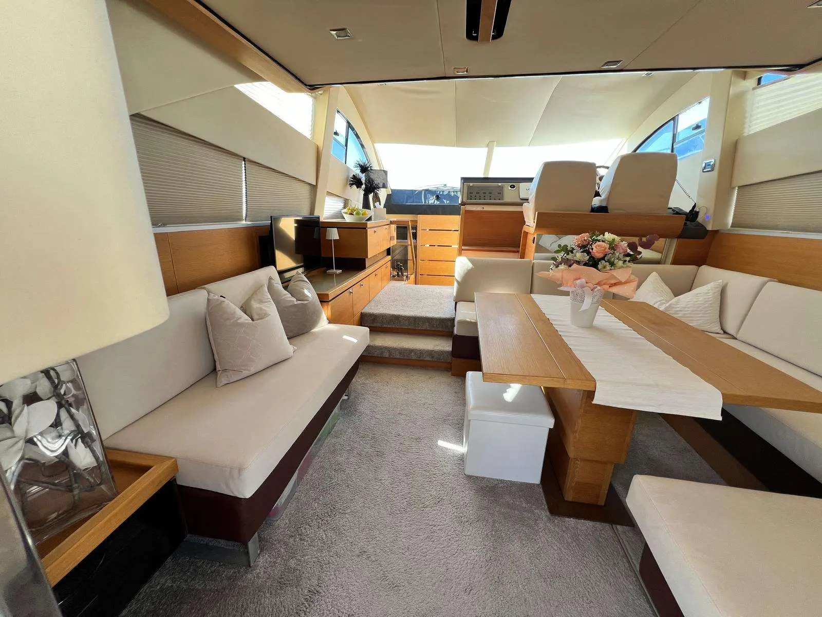 Fairline Phantom 48 — Vue du salon avec espace repas et poste de pilotage à l'avant.
