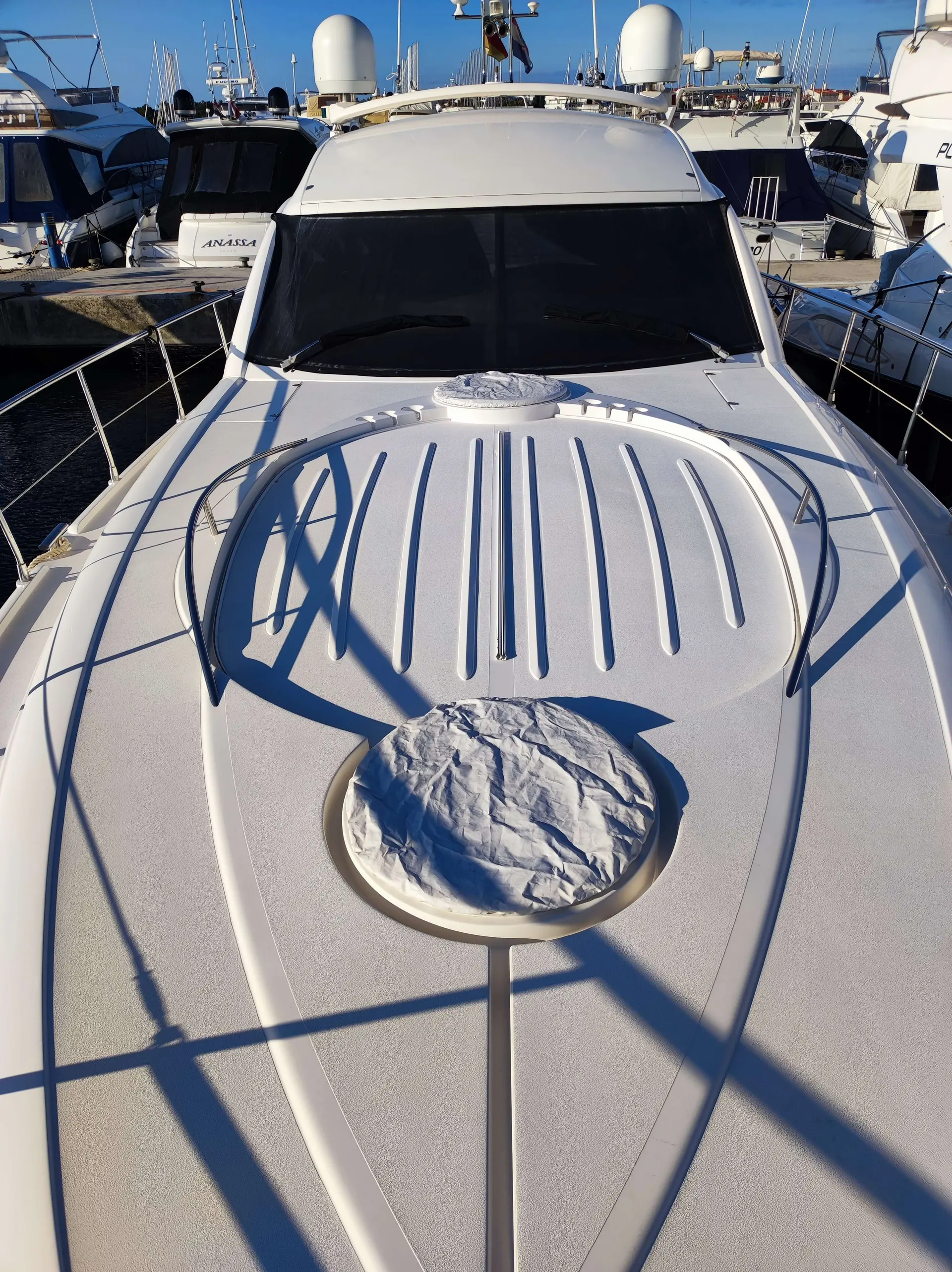 Fairline Targa 52 — Vue du pont avant et du pare-brise d’un bateau amarré dans une marina.