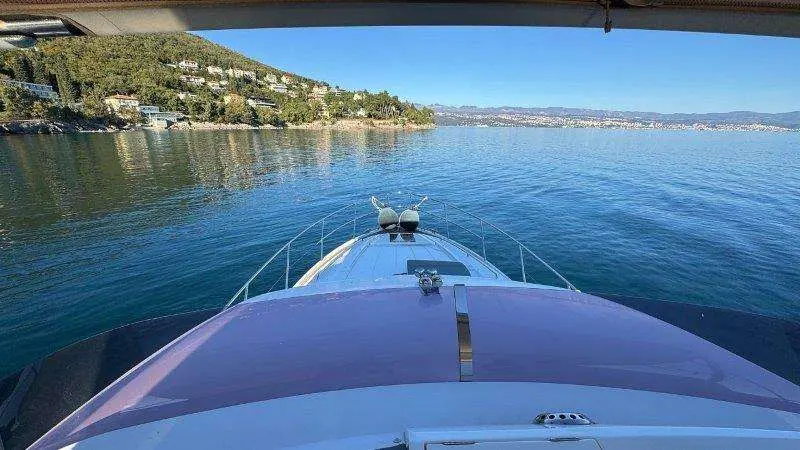 Princess 49 — Vue depuis l’avant d’un bateau sur un lac bordé de collines.