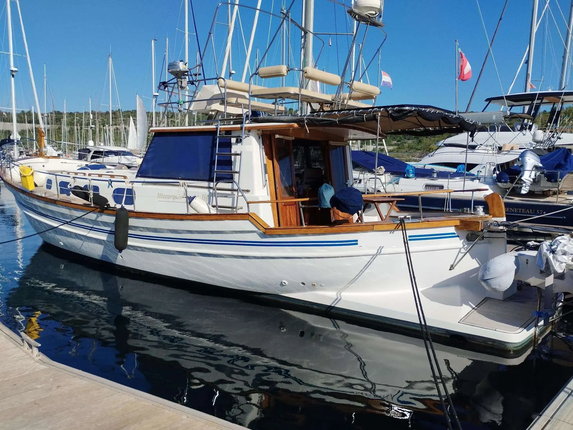 Menorquin 150 — Bateau à moteur blanc amarré dans une marina, photographié de trois quarts arrière.
