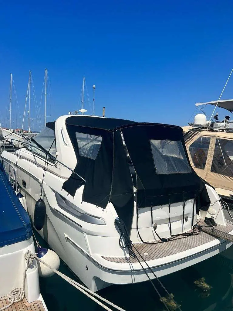 Bavaria Sport 38 — Bateau à moteur blanc vu de trois quarts arrière dans un port de plaisance.