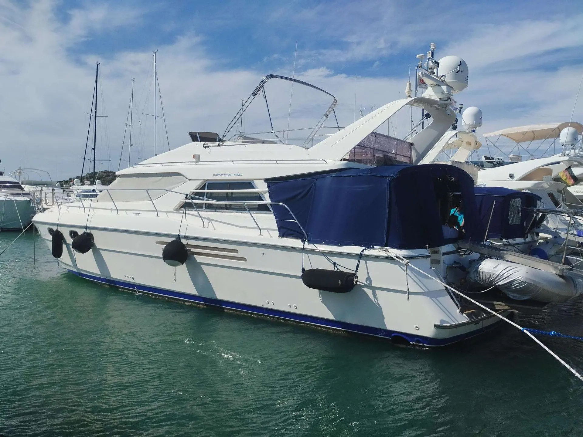 Princess 500 — Bateau à moteur blanc amarré dans une marina, vu de trois quarts bâbord.