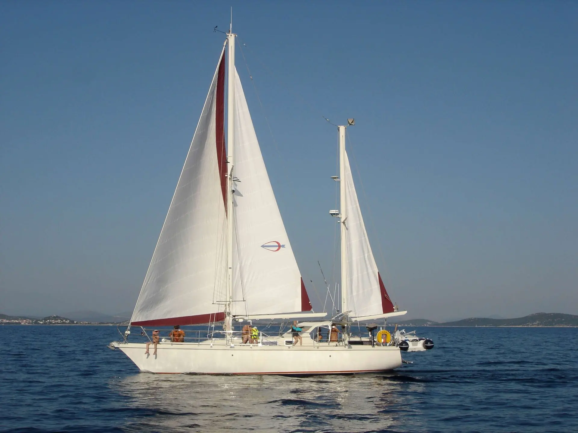 Amel Sharki — Voilier blanc à deux mâts, toutes voiles hissées, naviguant au large.