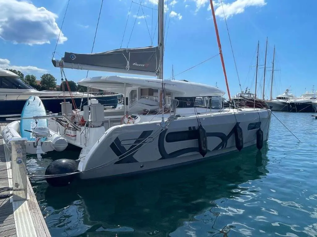 Excess Catamarans Excess 12 — Catamaran amarré dans une marina, vu de trois quarts arrière par tribord.