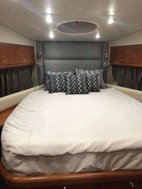 Sunseeker Manhattan 50 — Cabine avec couchette double, rangements en bois et éclairage encastré.
