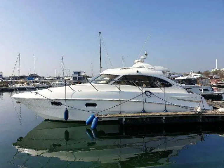 Sealine SC 39 — Bateau à moteur blanc amarré de profil dans un port de plaisance.