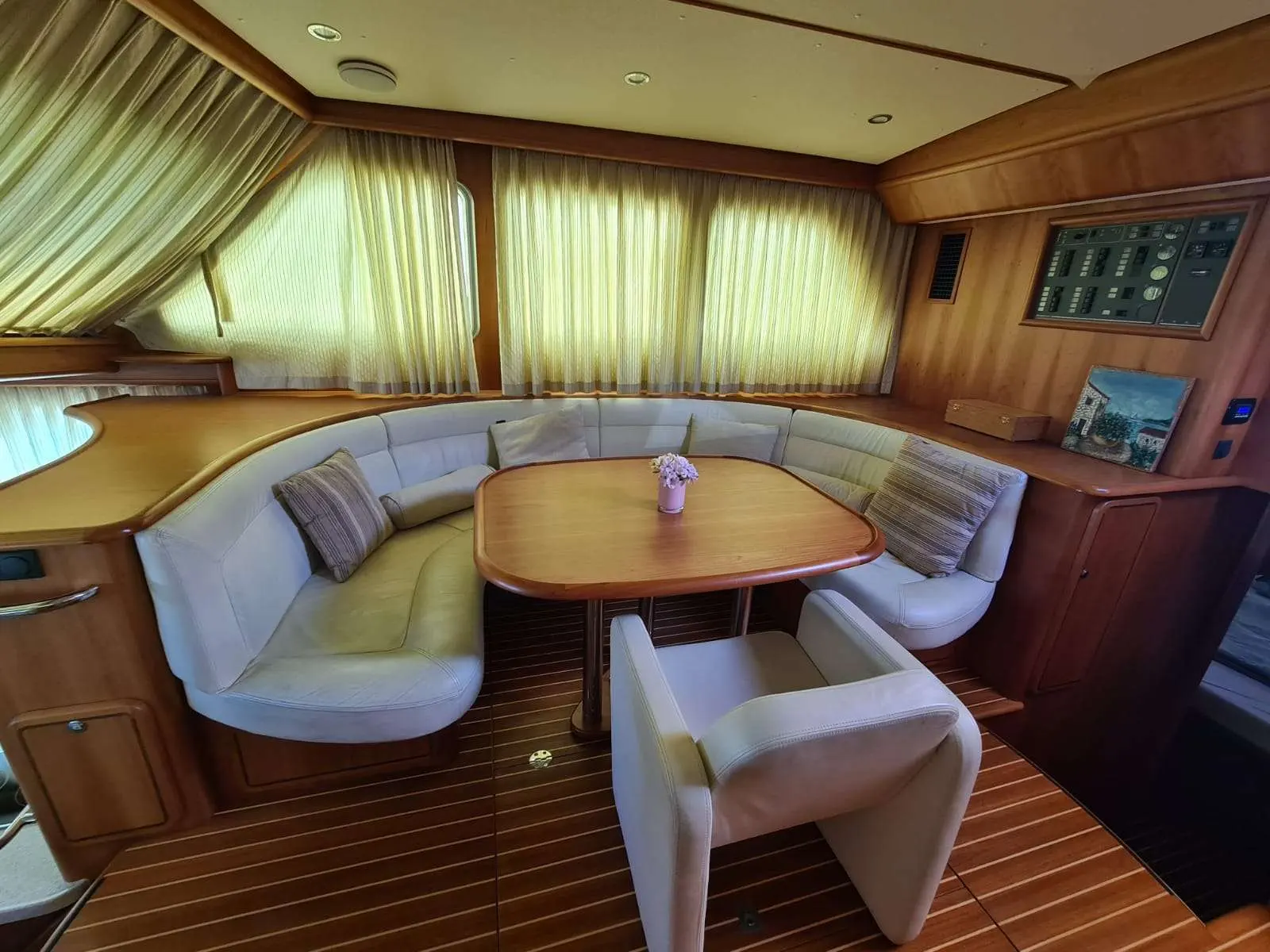 Linssen 470 Grand Sturdy — Salon intérieur avec banquette en U, table et panneau de commande.