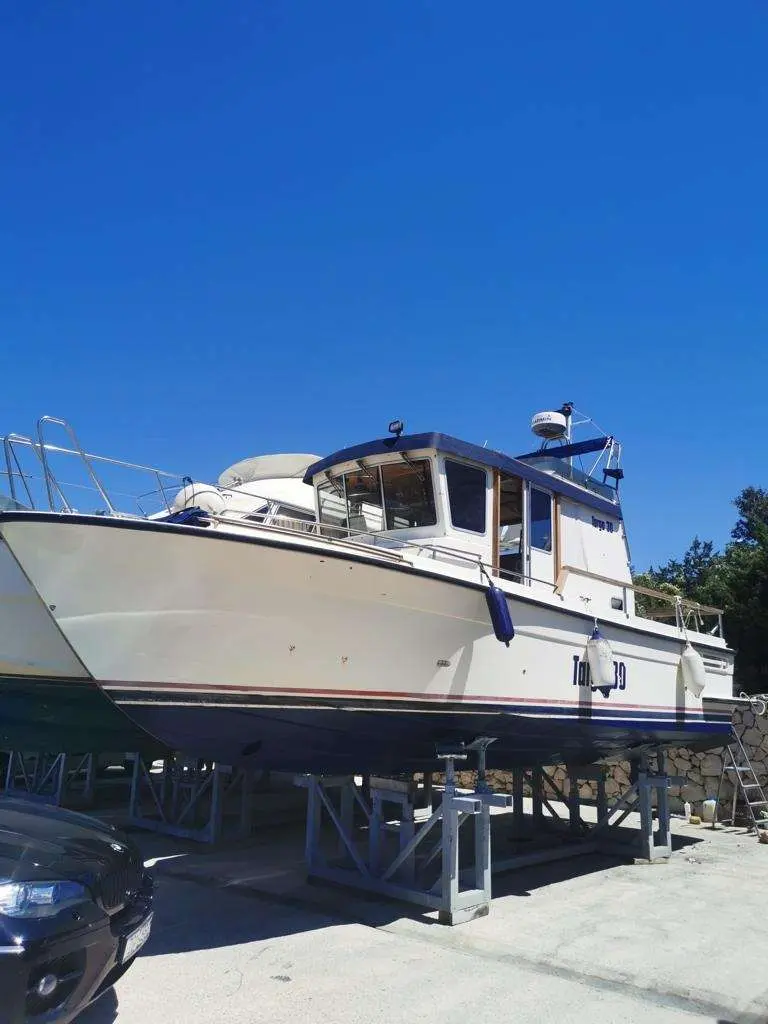 Fairline Targa 30 — Bateau blanc photographié à terre sur bers, vu de trois quarts avant.