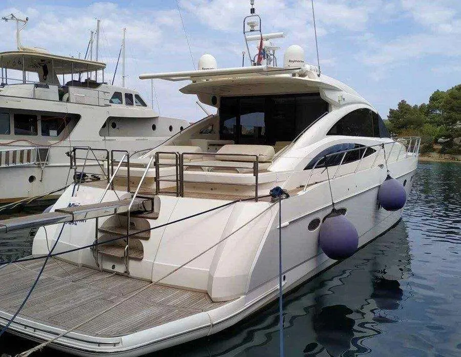 Princess V70 — Vedette à moteur blanche amarrée, vue de trois quarts arrière dans un port.