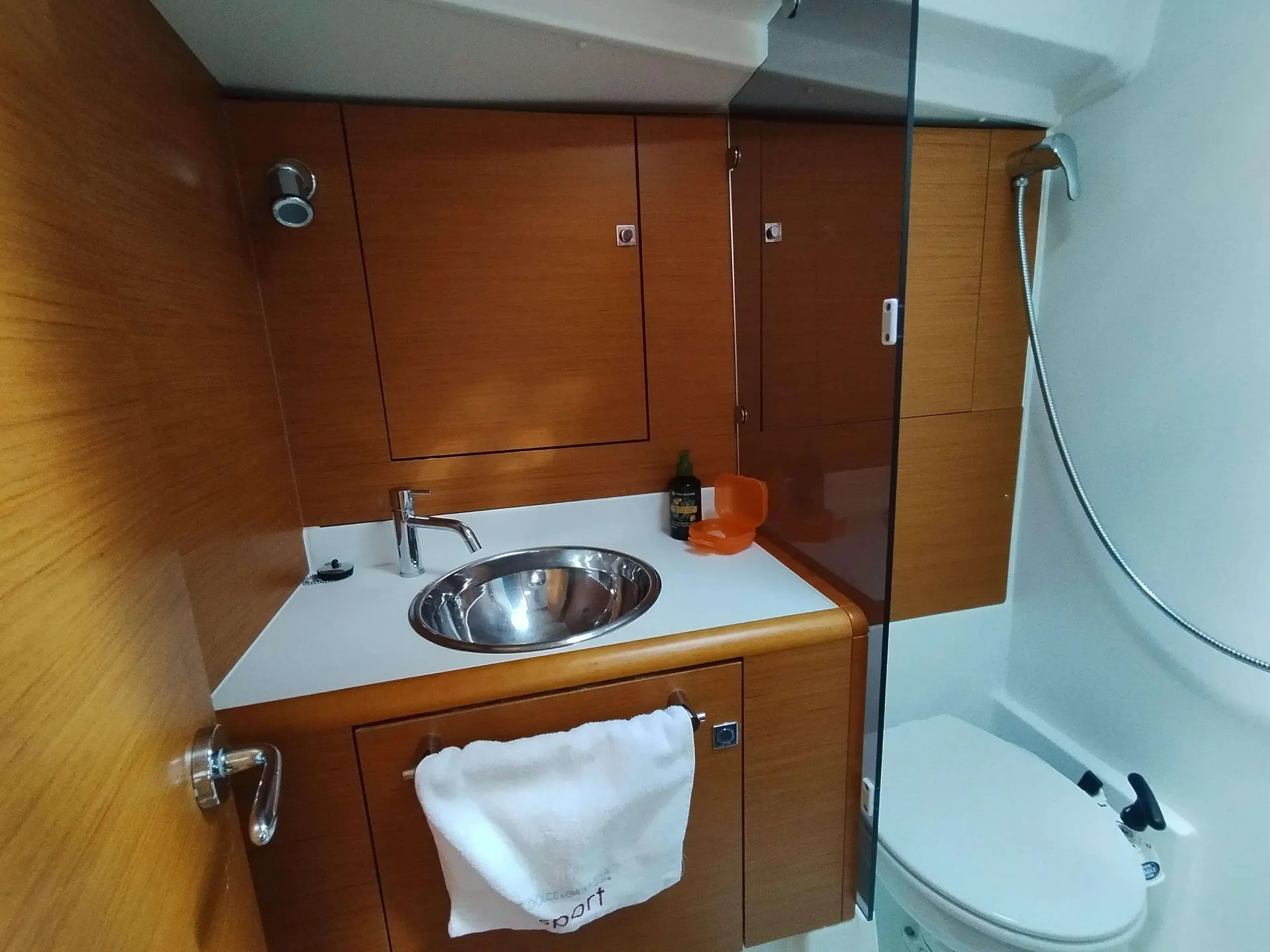 Jeanneau Sun Odyssey 439 — Salle d’eau avec lavabo, rangements en bois et toilettes à bord.