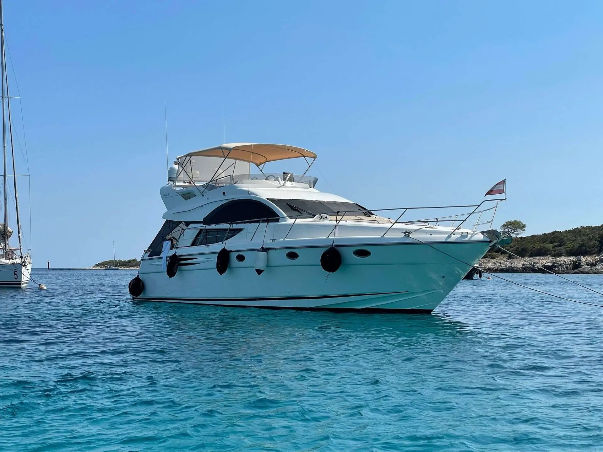 Fairline Phantom 50 — Vedette à moteur blanche photographiée au mouillage, vue tribord trois-quarts.