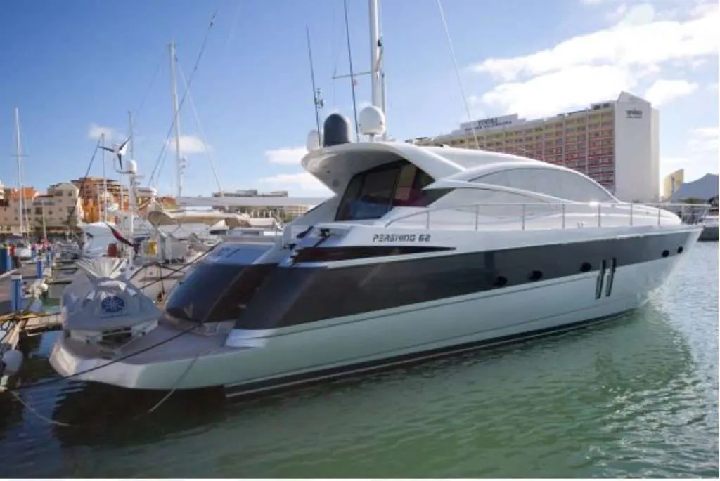Pershing 62 — Vedette blanche amarrée, vue de trois quarts arrière dans une marina.
