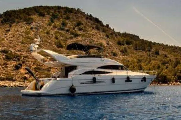 Princess 61 — Bateau à moteur blanc naviguant devant une côte rocheuse.